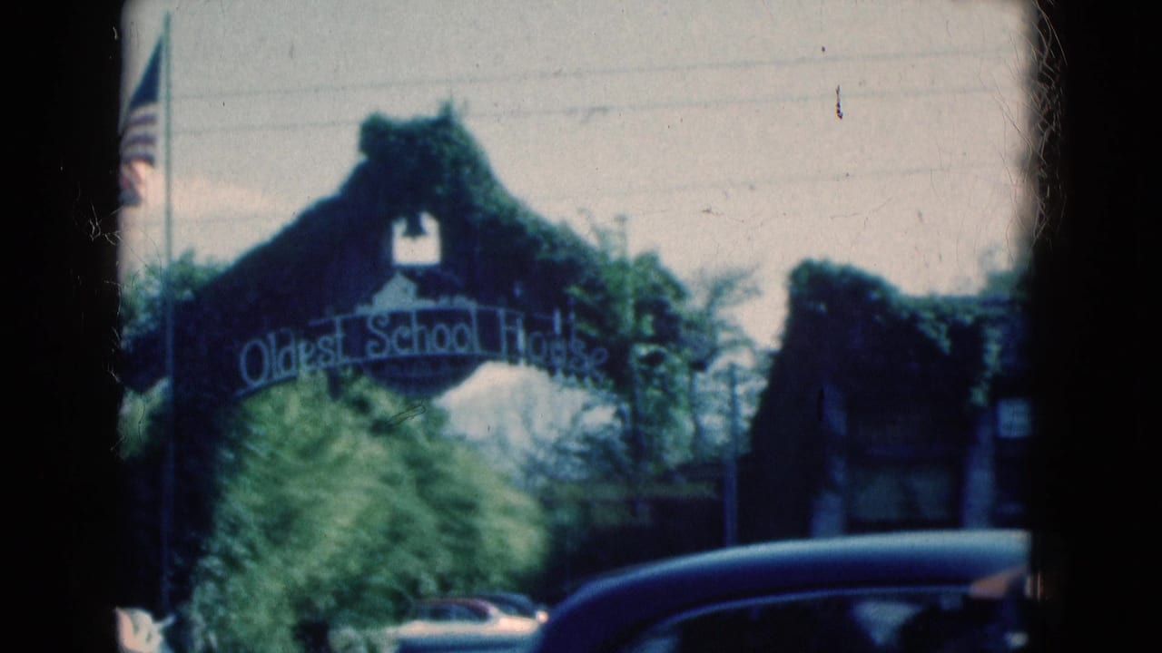Oldest School House arch seen from a moving vehicle with a car crossing the lower frame.