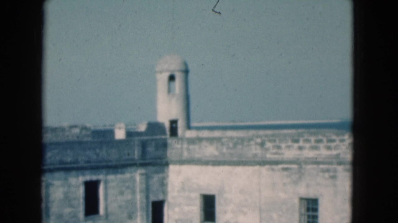 1975 Florida 8mm view of a pale stone fortress wall, small domed tower, and dark foreground framing.