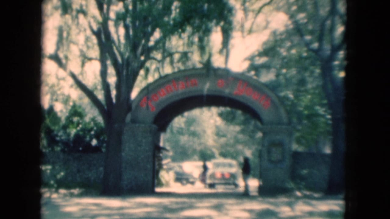 Fountain of Youth arch with cars passing under it and a person beside the entrance.