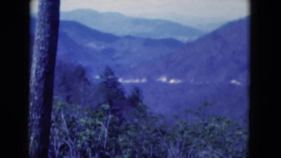 Soft 1975 8mm footage frames distant ridges and green foreground vegetation from a visitor's overlook in Florida.