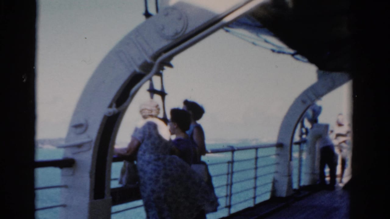 Adults on a Florida boat deck in 1975 appear to look toward shore from beneath white ship arches.