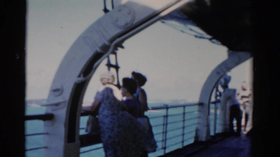 Adults on a Florida boat deck in 1975 appear to look toward shore from beneath white ship arches.