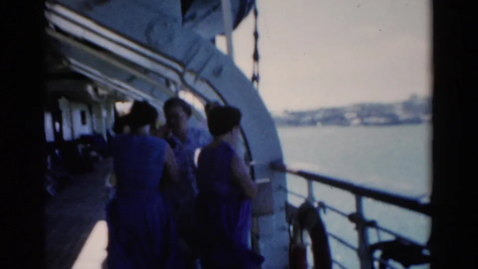 Women on a 1975 Florida boat deck appear in conversation near the rail, with shoreline visible across the water.