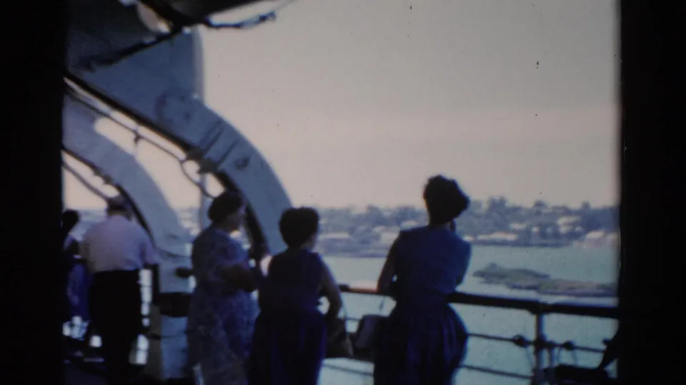 Home-movie view of passengers on a 1975 Florida cruise ship deck, including women looking toward the shoreline.