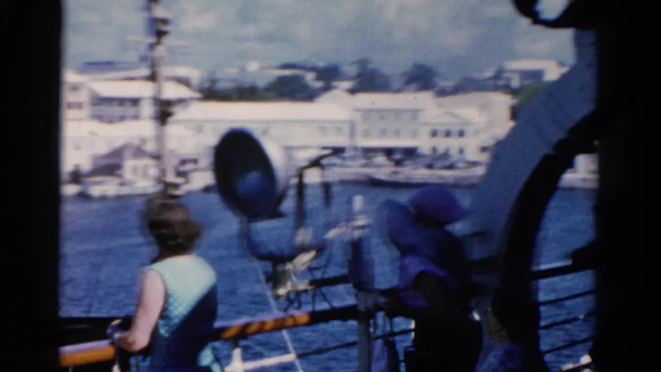 1975 Florida harbor view from a ship deck, with the woman at the rail partly turned away and deck equipment in the foreground.