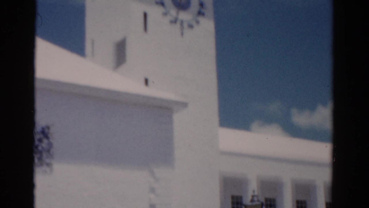 White clock tower and upper facade partly obscured by a dark film-strip divider.