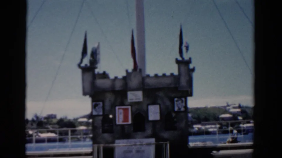 Castle-like decorative structure with flags and framed panels on a cruise ship deck in the 1975 Florida footage.