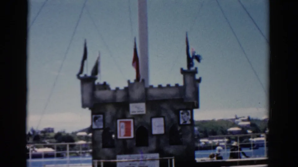 1975 Florida travel frame showing the ship's castle-like deck decoration, flags, railings, and distant waterfront.