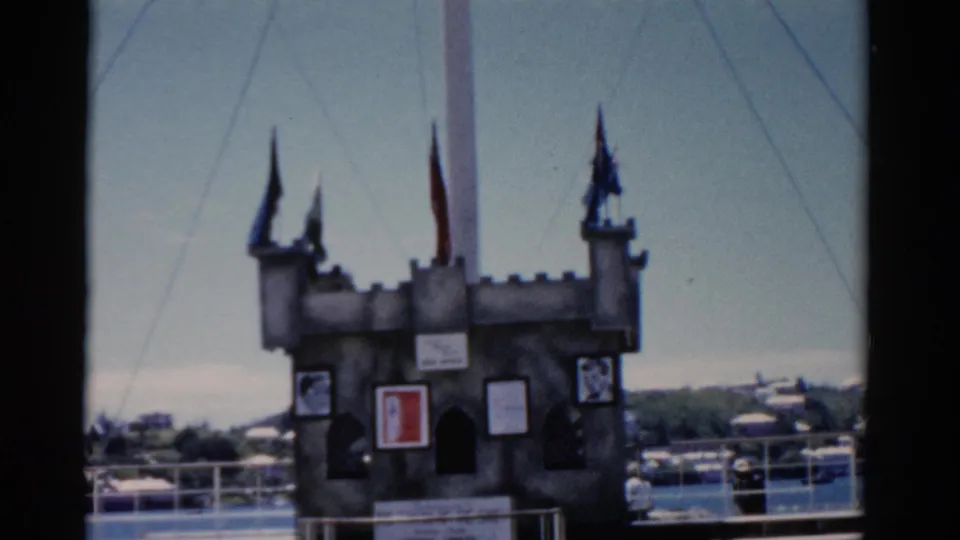 Final frame of the 1975 Florida clip, centered on a castle-like deck display with flags and shoreline beyond.