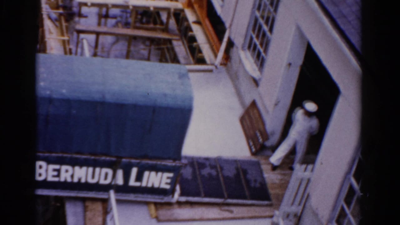 1975 Florida port entrance with a blue awning, visible Bermuda Line sign, and a man in a white sailor uniform at the doorway.