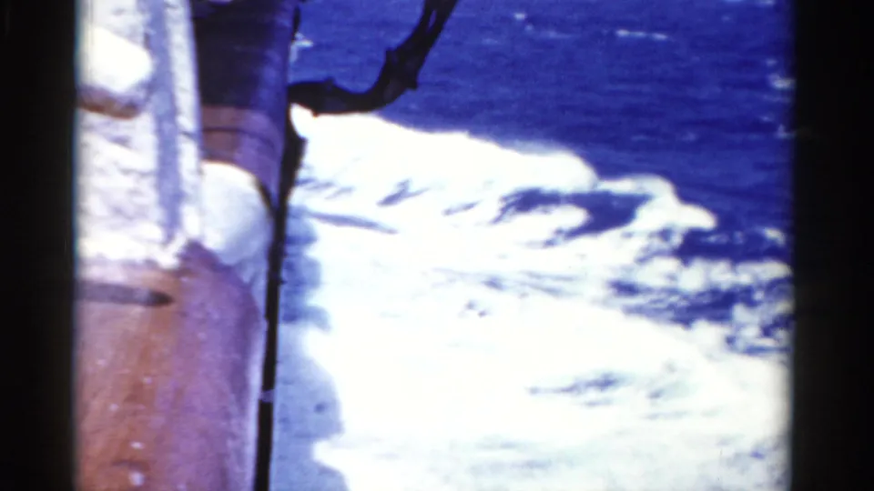 The camera looks down from the cruise ship toward foaming white wake on blue water in 1975 Florida travel footage.