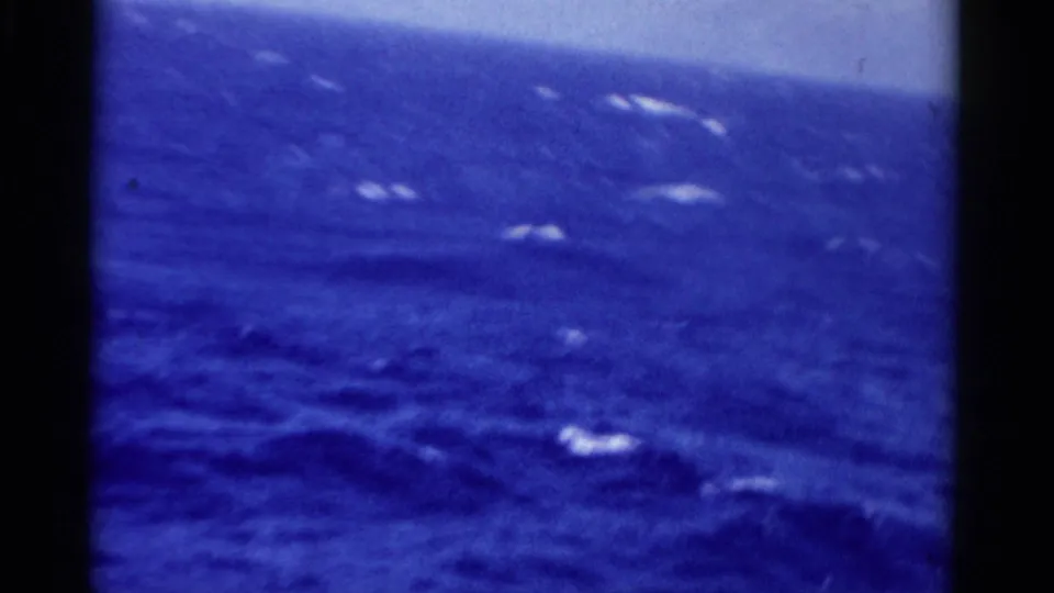 1975 Florida 8mm frame showing deep blue open sea, scattered whitecaps, and a faint horizon from a moving boat.