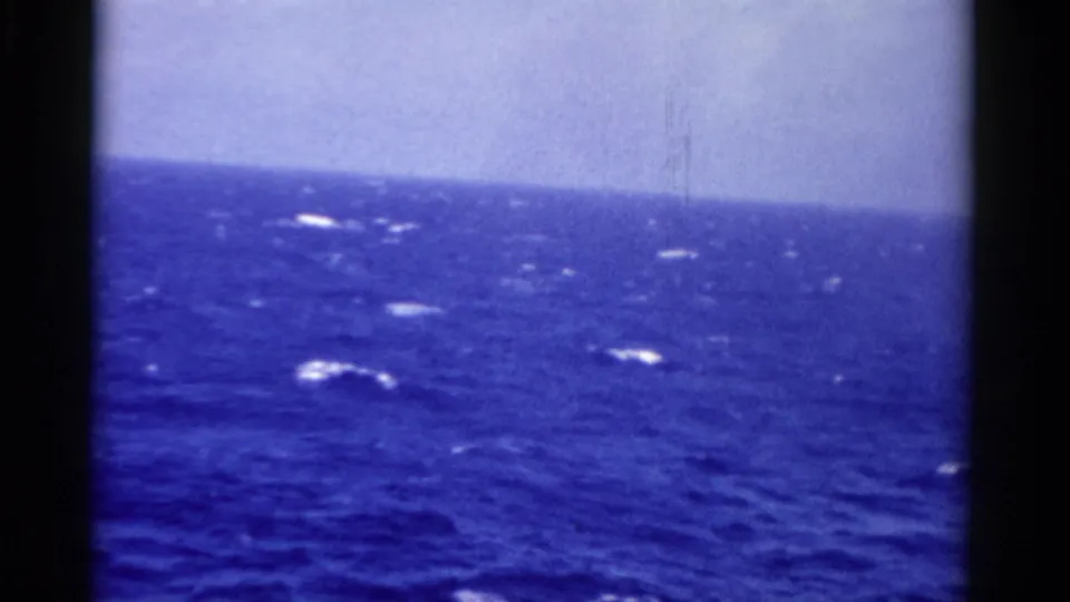 1975 Florida 8mm frame showing open blue ocean, scattered whitecaps, a pale horizon, and dark gate borders.