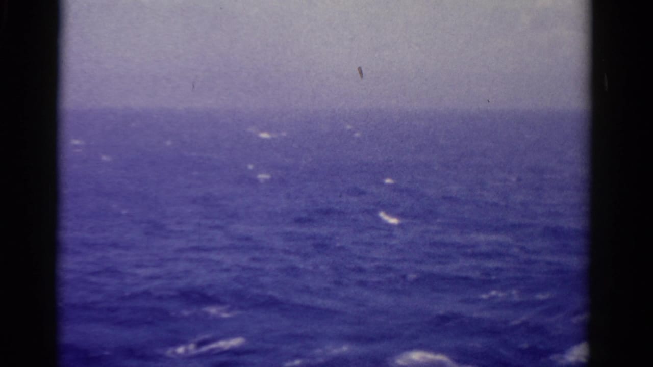 1975 Florida-linked shipboard view across rough blue water, with whitecaps under a pale overcast sky.