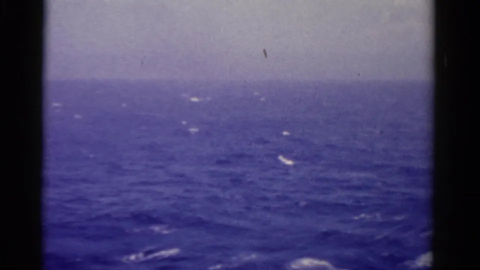 1975 Florida-linked shipboard view across rough blue water, with whitecaps under a pale overcast sky.