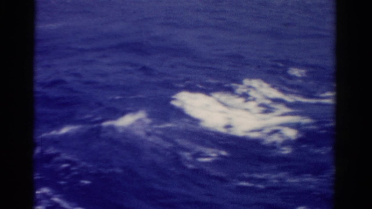 1975 Florida 8mm home-movie frame showing deep blue ocean water and white foam from a moving vessel.