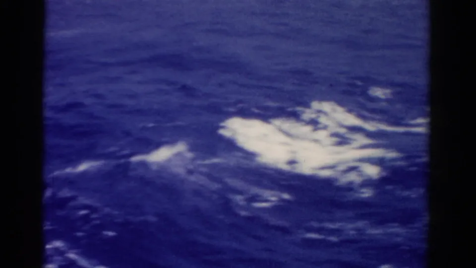 1975 Florida 8mm home-movie frame showing deep blue ocean water and white foam from a moving vessel.