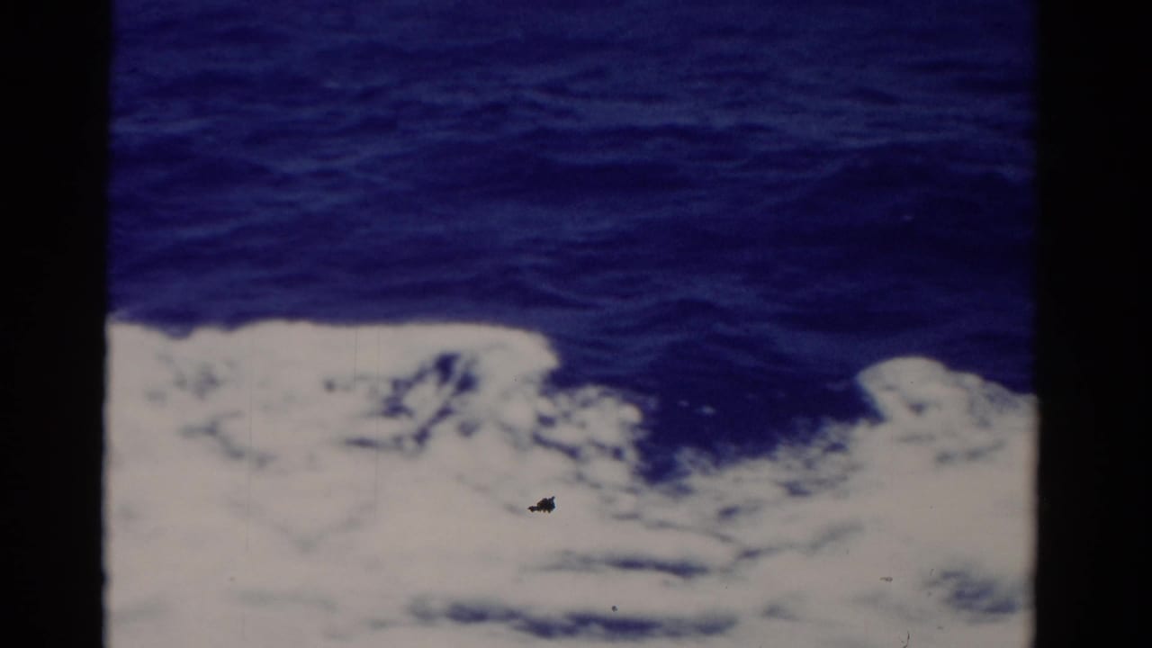 1975 Florida 8mm view of bright white wake breaking across dark blue sea from a boat perspective.