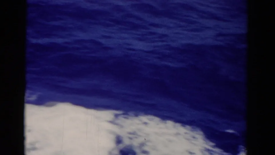 1975 Florida 8mm view of churning sea and white foam, framed by black gate edges and slight film wear.