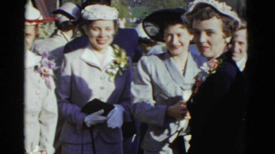 Women in 1970s formal outfits pose outdoors in Boston, with hats, corsages and a small clutch visible among the group.