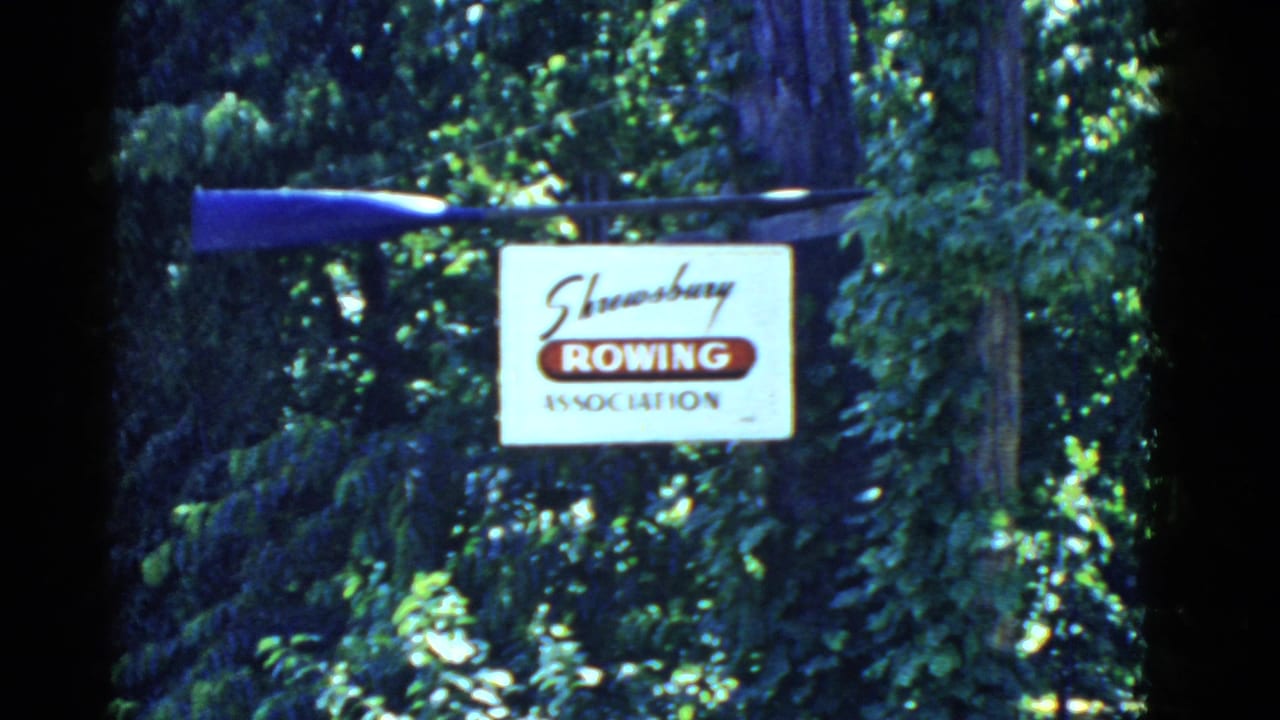 Shrewsbury Rowing Association sign hanging among trees with a blue oar above it.