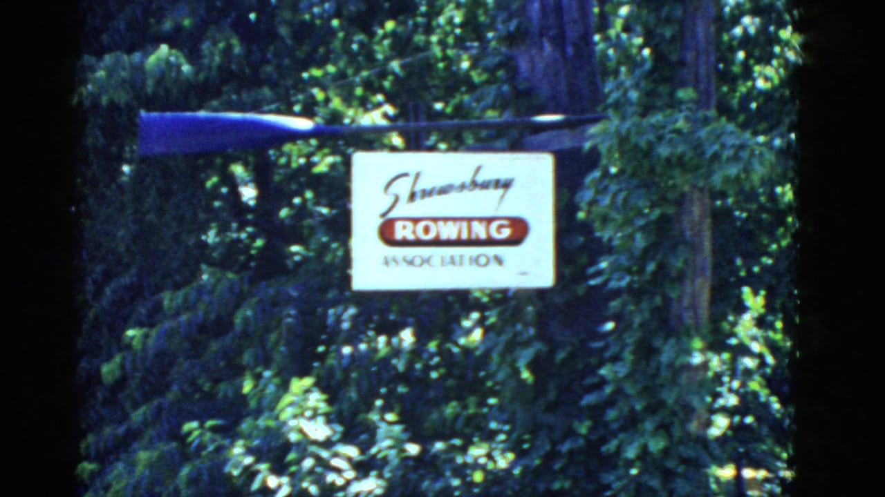 A similar 1975 Massachusetts 8mm view holds on the Shrewsbury Rowing Association sign and oar against dense greenery.