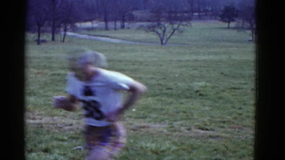 The second runner, wearing a white shirt marked 38, passes close to the camera in the 1975 Boston field scene.