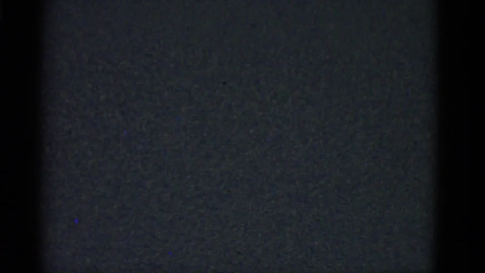 Dark closing frame from the Boston 1975 home-movie clip, showing underexposed film texture with no distinct figures visible.