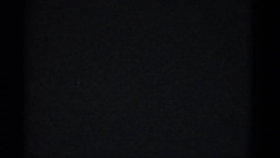 Underexposed end frame from the 1975 Boston party clip, with the scene mostly obscured by darkness.