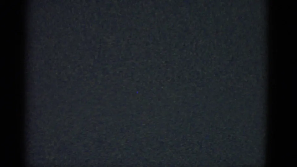 Final dark 1975 8mm frame from Boston metadata, dominated by grain, vertical black banding, and muted blue-gray exposure.