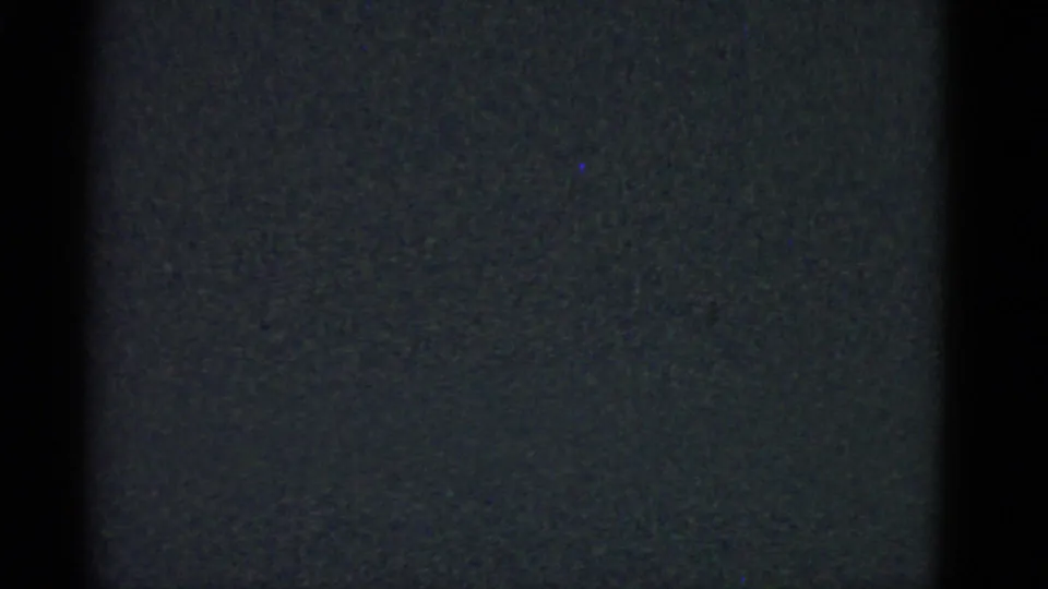 Underexposed portion of the 1975 8mm home movie with visible grain and black frame edge.