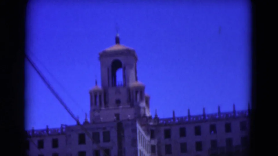 Close 1975 Florida 8mm view of the tower-like rooftop structure and upper levels of a white resort-style building.