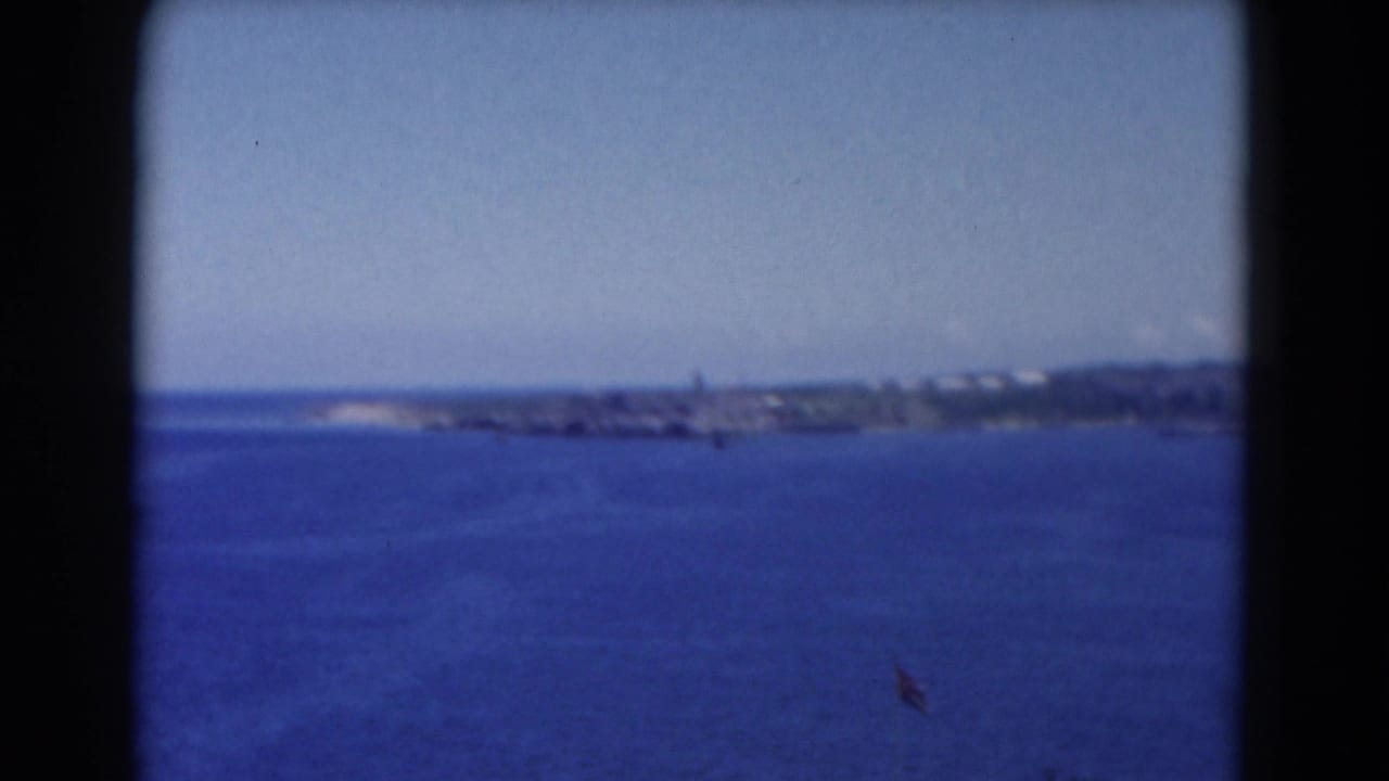 Ocean and distant shoreline framed by dark 8mm film borders.