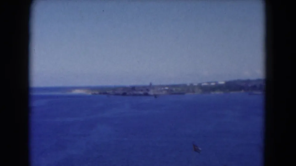 1975 Florida 8mm footage shows a wide ocean view with low distant shoreline before the boarding scene.