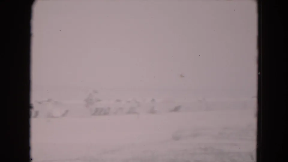 Highly exposed 1975 8mm Florida frame with faint snow-like ground and barely defined distant structures.
