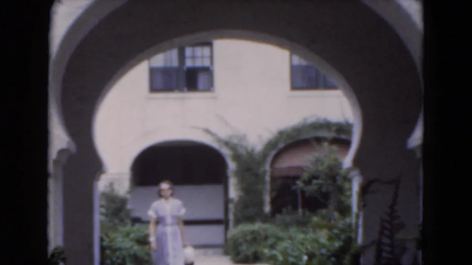 The final frame shows the woman standing under the arched walkway, surrounded by shrubs and sunlit stucco walls in Florida.
