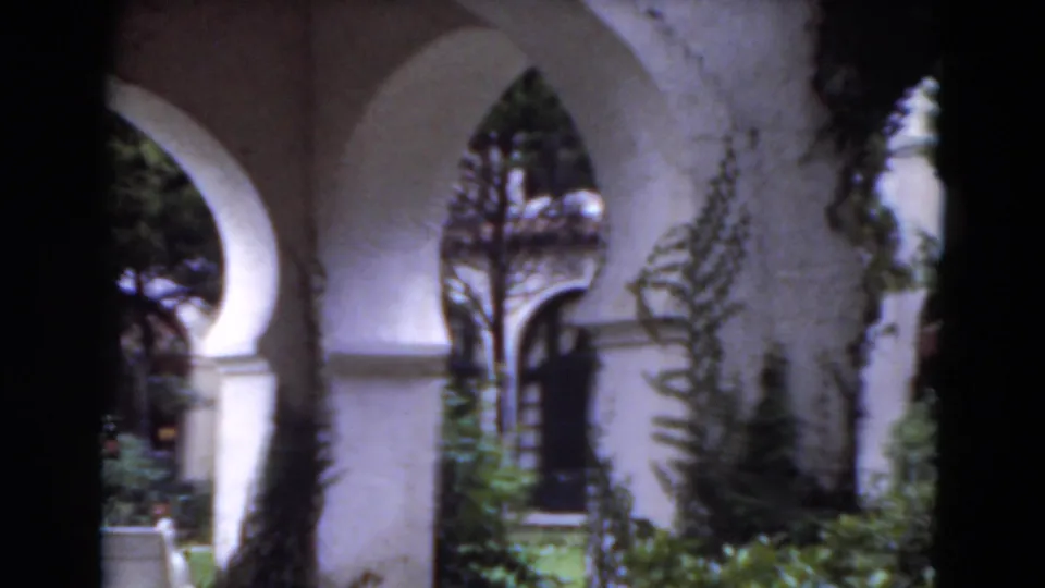The final frame shows white stucco arches, garden foliage, and a dark doorway in a softly exposed 1975 Florida home-movie view.