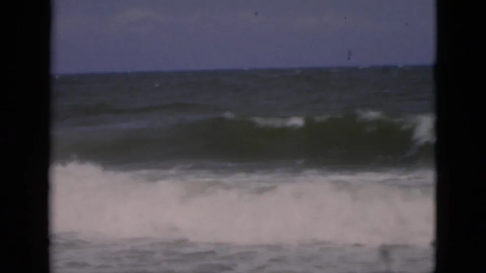1975 Florida 8mm beach footage showing choppy surf and white foam framed by dark film borders.