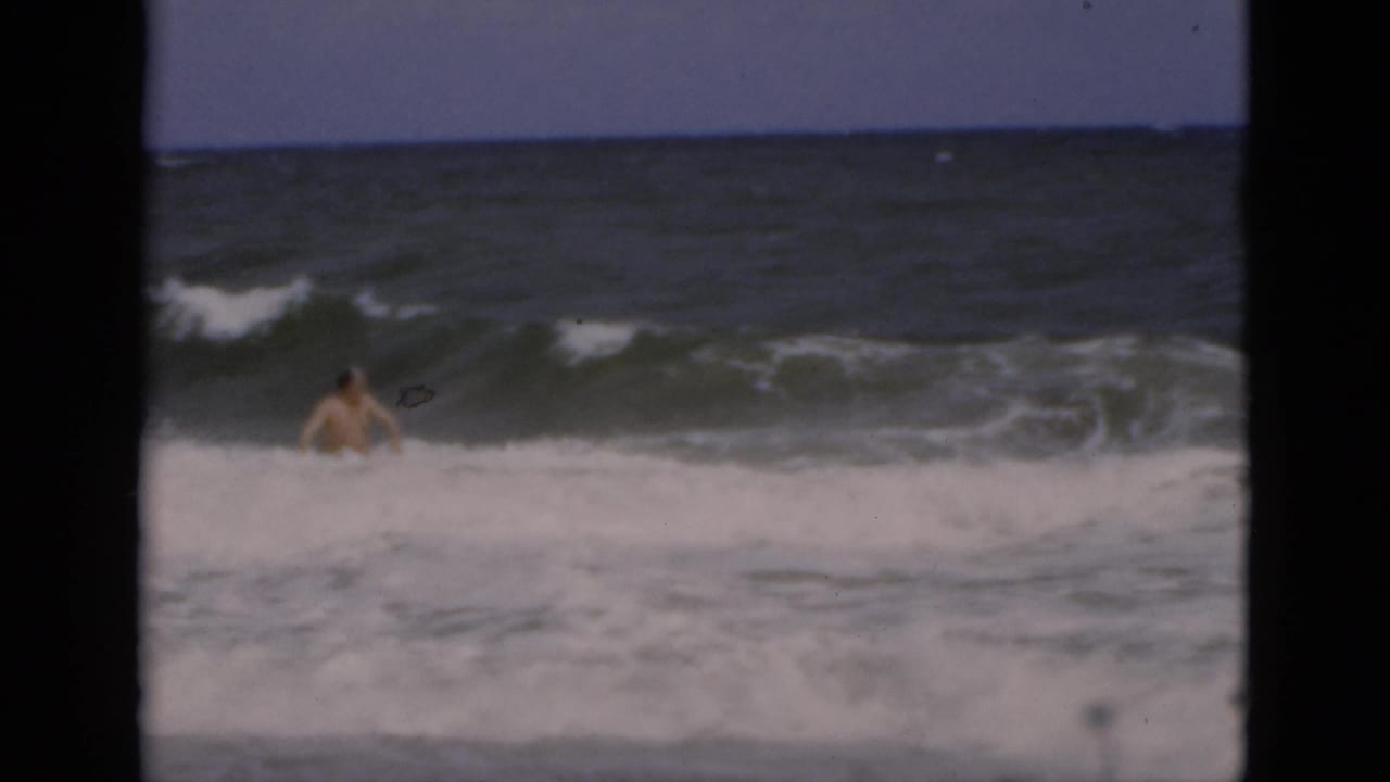 Man partly surrounded by a breaking wave in heavy surf.