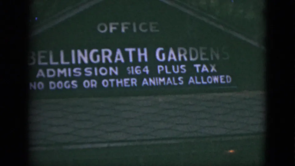 1975 Florida travel frame showing the Bellingrath Gardens sign, admission wording, and no-animal rule in soft focus.