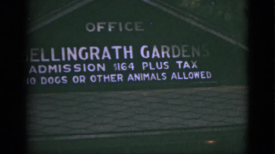 Soft 8mm close-up of the Bellingrath Gardens sign, cropped by the camera with admission and rule text visible.