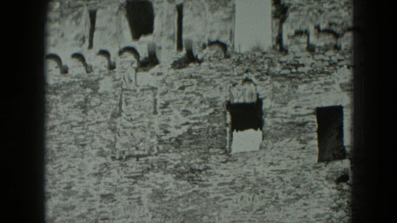 Stone ruin wall with arched openings and dark window voids.