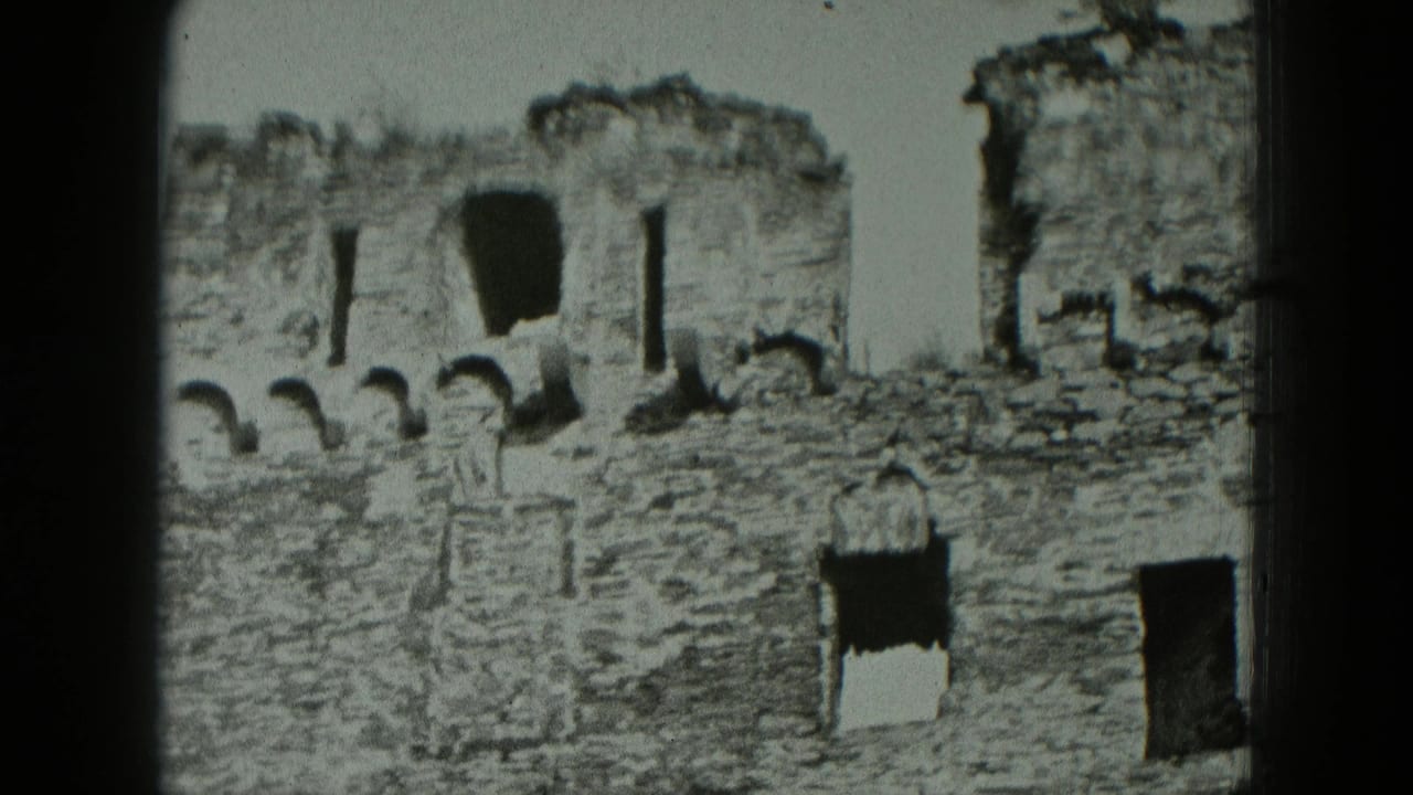 Black-and-white 8mm view of German castle fortress ruins, with rough stonework, arched gaps, and dark rectangular openings.