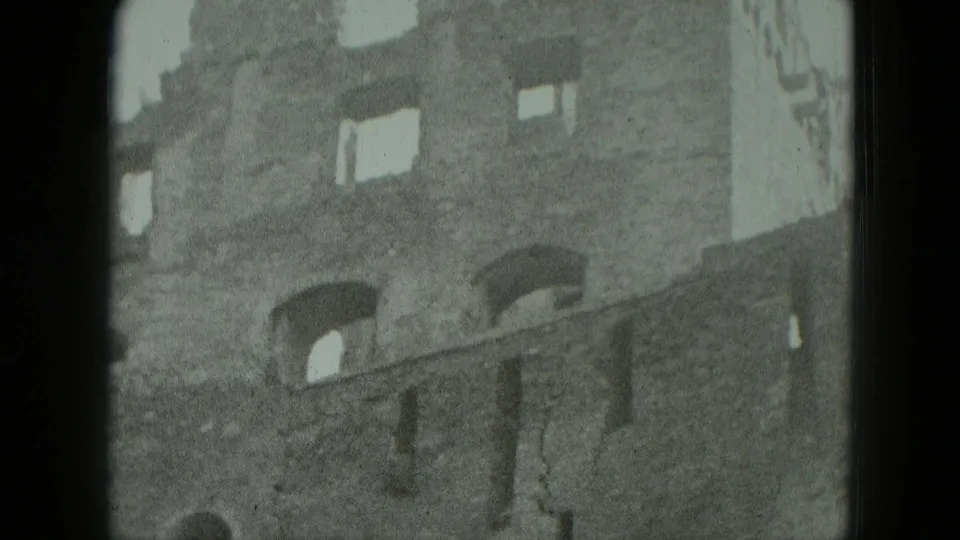 1951 Germany 8mm frame showing a damaged brick facade with arched window openings and a partly broken roofline.