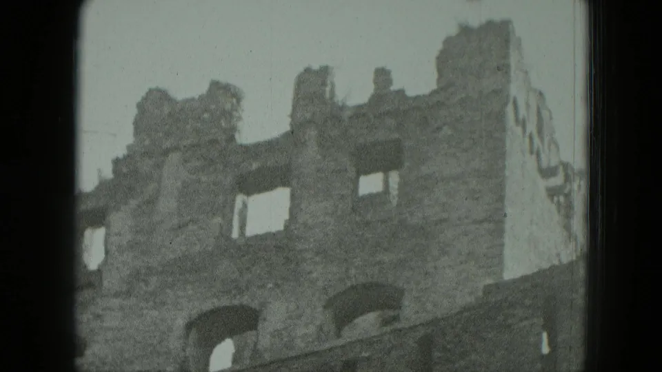 1951 Germany 8mm frame of the jagged top of a damaged brick building with empty rectangular and arched openings.
