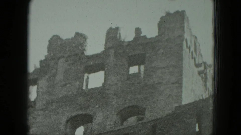 1951 Germany 8mm frame showing a weathered stone ruin with arched openings, broken windows, and dark film borders.