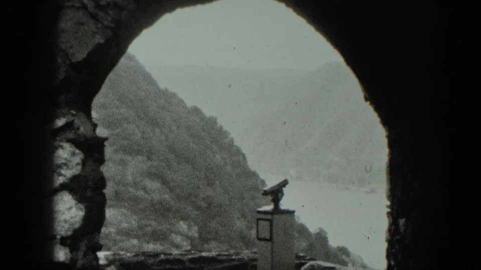 1951 West Germany fortress overlook showing a dark arch, river valley, wooded slope, and coin-operated viewing binocular.