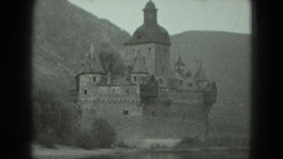 Black-and-white 1951 8mm view of a castle-like German riverside landmark centered between dark vertical film-frame borders.