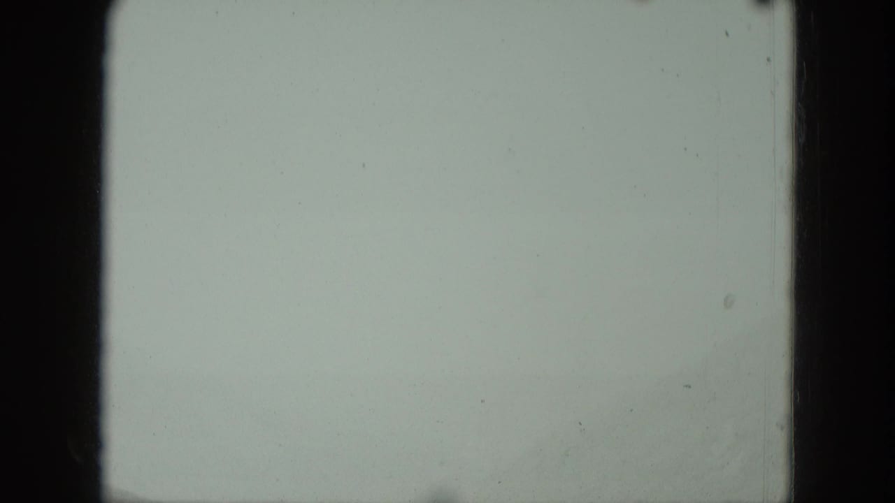 Mostly blank pale frame with dark 8mm film borders and faint marks.