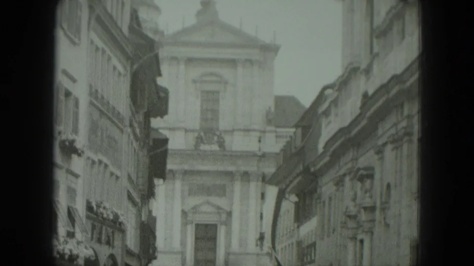 1951 West Germany street view looking between older buildings toward a church facade with columns and a tall upper window.